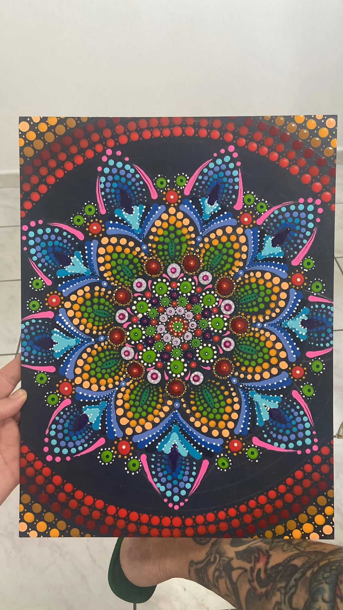 Quadro de mandala pontilhada recém-finalizado, segurado à mão